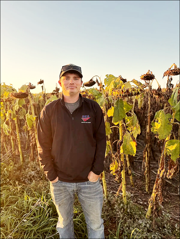 Bo Beer standing in sunflower field